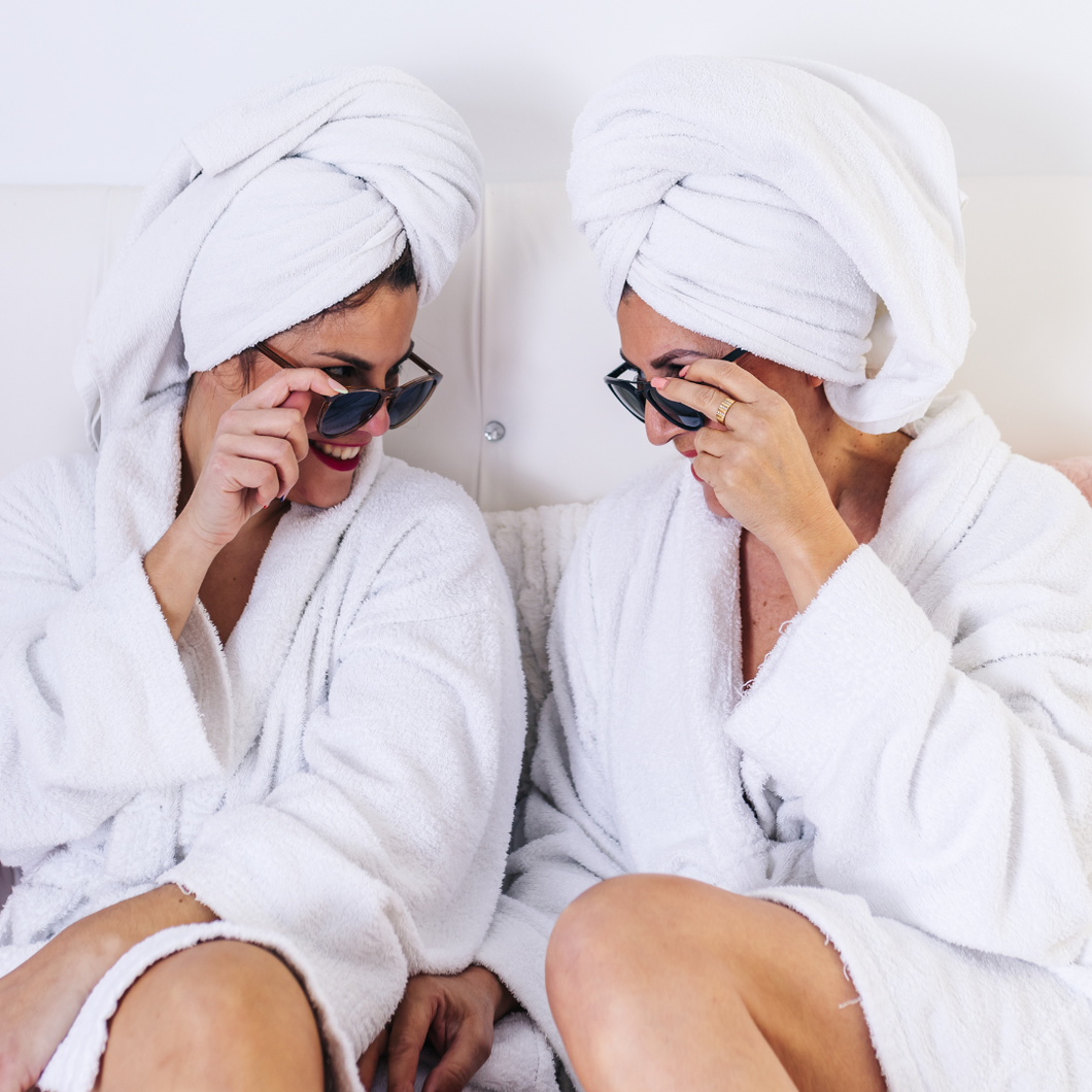Two women in white robes and towels on heads having a spa day in Fleming Island